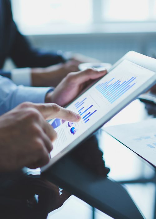 Image of businessperson pointing at document in touchpad at meeting